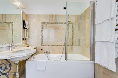 a bathroom with a tub and a sink and a shower at Hotel Cellini in Rome