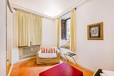 a living room with a chair and a window at Palazzo Donarelli in Rome