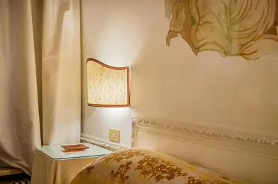 a bedroom with a bed and a lamp on a wall at Palazzo Donarelli in Rome