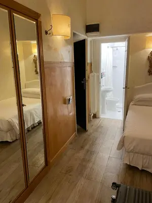 a room with a tv and a bedroom with a bed at Hotel Fontana in Rome
