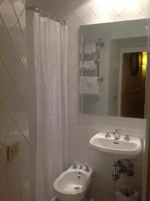 a bathroom with a sink and a white shower curtain at Hotel Fontana in Rome