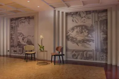 a room with two chairs and a painting on the wall at NH Roma Villa Carpegna in Rome