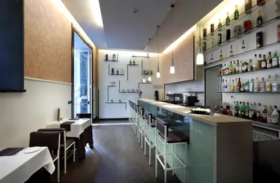 a restaurant with a bar and some tables and chairs at Exe International Palace in Rome