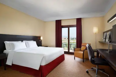 a hotel room with a bed and a desk and a window at Courtyard by Marriott Rome Central Park in Rome