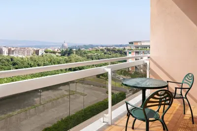 a balcony with a table and chairs and a view at Courtyard by Marriott Rome Central Park in Rome