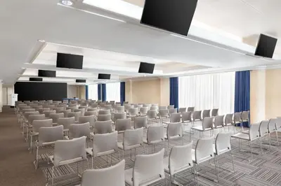 a conference room with white chairs and a podium at Courtyard by Marriott Rome Central Park in Rome