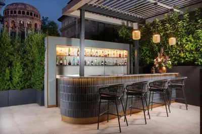a bar in a garden with chairs around it at NH Collection Roma Centro in Rome