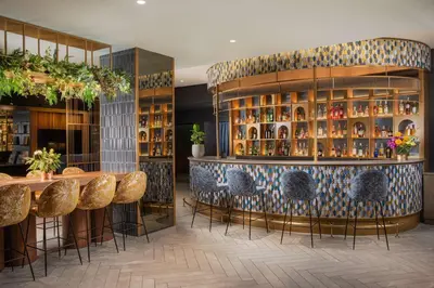 a lobby with a bar with stools at NH Collection Roma Centro in Rome