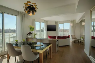a living room with a table and chairs and a couch at NH Collection Roma Centro in Rome
