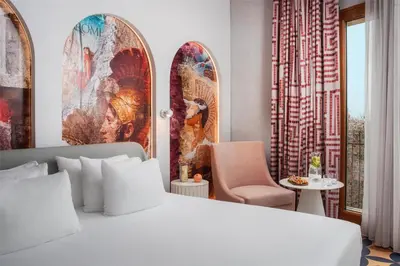 a bedroom with a bed and a chair and a table at nhow Roma in Rome