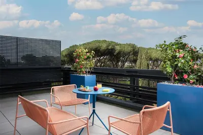 a patio with chairs and a table on a balcony at nhow Roma in Rome