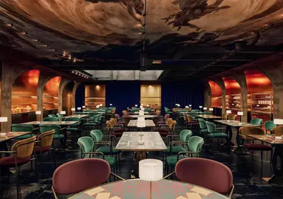 a dining room with tables and chairs and a painting on the ceiling at nhow Roma in Rome