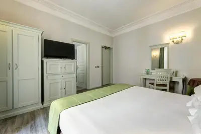 a white bedroom with a bed and a flat screen tv at BB Hotels Smarthotel Bailey's in Rome