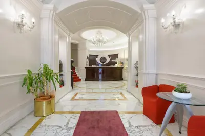 a lobby with a red couch and a table at Gambrinus Hotel in Rome