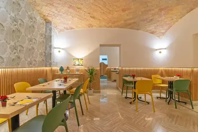 a dining room with tables and yellow chairs at Gambrinus Hotel in Rome