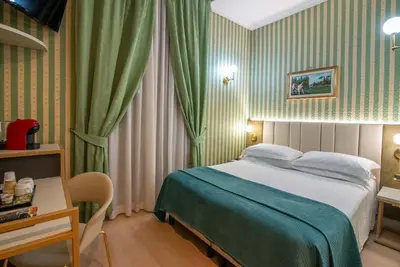a hotel room with a bed and a table and a desk at Gambrinus Hotel in Rome