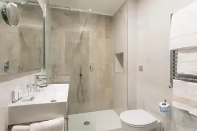 a bathroom with a shower and a toilet and a sink at Marcella Royal Hotel - Rooftop Garden in Rome