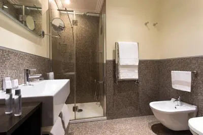 a bathroom with a shower and a sink and a toilet at Marcella Royal Hotel - Rooftop Garden in Rome