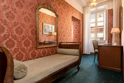 a bedroom with a bed and a mirror on the wall at Marcella Royal Hotel - Rooftop Garden in Rome