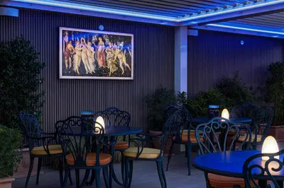 a restaurant with tables and chairs and a picture on the wall at Marcella Royal Hotel - Rooftop Garden in Rome