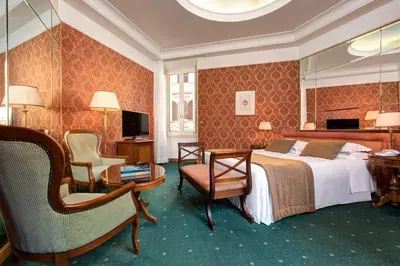 a hotel room with a bed and a chair at Marcella Royal Hotel - Rooftop Garden in Rome