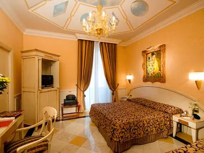 a bedroom with a bed and a chandelier at Hotel Bolivar in Rome