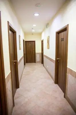 a hallway with doors and a tiled floor at Hotel Alex Square in Rome