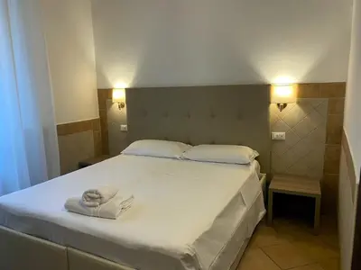 a bedroom with a bed with towels on it at Hotel Alex Square in Rome