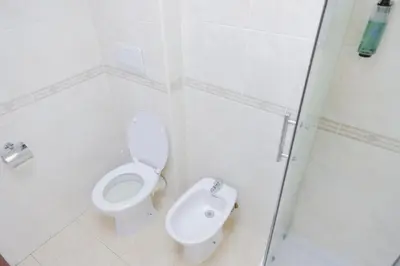 a white bathroom with a toilet and a bidet at Hotel Alex Square in Rome