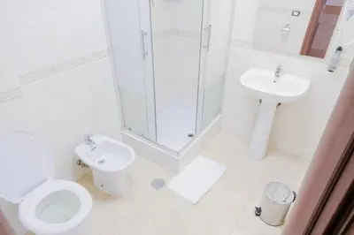 a bathroom with a toilet and a shower and a sink at Hotel Alex Square in Rome