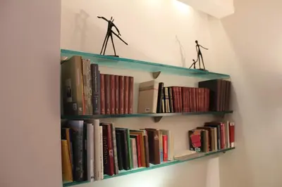 a book shelf with two figurines on top of books at Hotel Garda in Rome