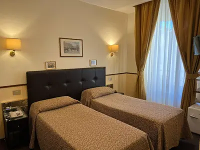 a hotel room with two beds and a window at Hotel Garda in Rome