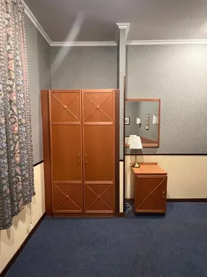 a room with a closet and a cabinet and a table at Hotel Garda in Rome