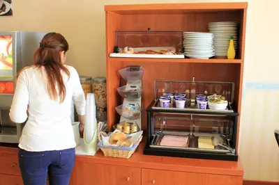 a woman standing in front of a shelf with food at Hotel Orlanda in Rome