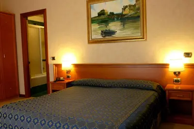 a hotel room with a bed and two lamps at Hotel Orlanda in Rome