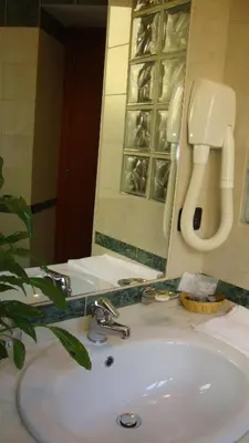 a bathroom sink with a mirror and a phone at Hotel Orlanda in Rome