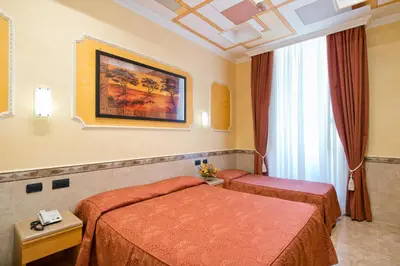 a hotel room with two beds and a window at Hotel Marco Polo Rome in Rome