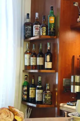 a shelf filled with lots of bottles of whiskey at Hotel Marco Polo Rome in Rome