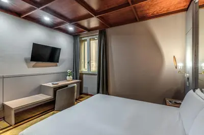 a hotel room with a bed and a desk and a tv at Madison Hotel in Rome