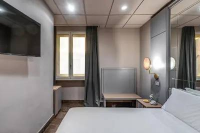 a hotel room with a bed and a tv at Madison Hotel in Rome