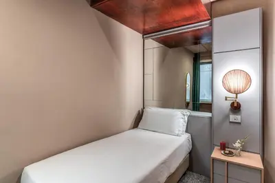 a small room with a bed and a mirror at Madison Hotel in Rome