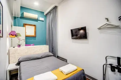 a small bedroom with a bed and a tv at Hotel Seiler in Rome