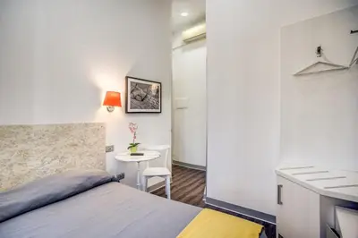 a small bedroom with a bed and a table at Hotel Seiler in Rome
