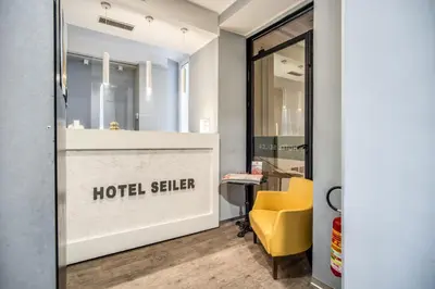 a reception area with a yellow chair in a hotel salon at Hotel Seiler in Rome