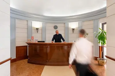 a man standing at a bar in a room at Hotel Hiberia in Rome