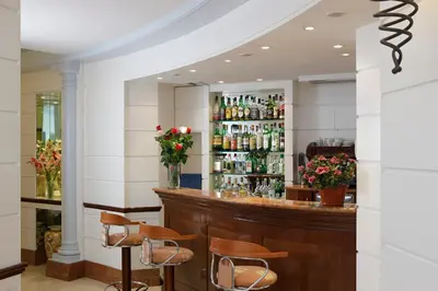 a bar in a restaurant with chairs and bottles at Hotel Hiberia in Rome