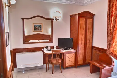 a room with a desk with a computer and a mirror at Hotel Hiberia in Rome