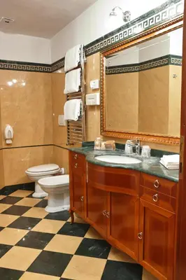 a bathroom with a sink and a toilet and a mirror at Hotel Hiberia in Rome