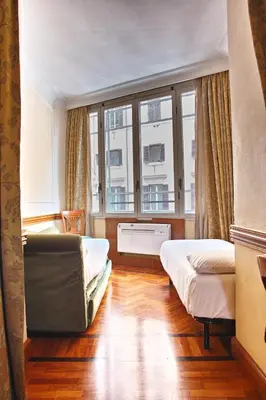 a bedroom with two beds and a window at Hotel Hiberia in Rome
