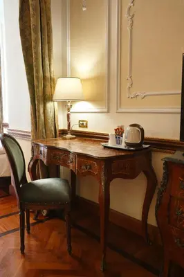 a desk in a room with a lamp and a chair at Hotel Hiberia in Rome